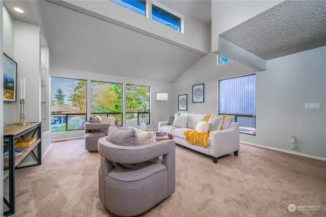 From the entry, step into an expansive living room with soaring ceilings and grand picture and clerestory windows that flood the space with natural light.