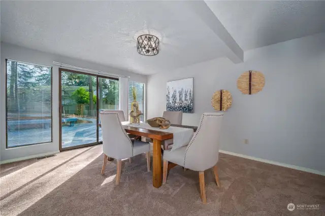 From the living room, step into the spacious dining room, designed to accommodate both intimate dinners and larger gatherings. Sliding doors lead to an expansive deck, perfect for seamless indoor-outdoor living and al fresco dining on warm summer nights.