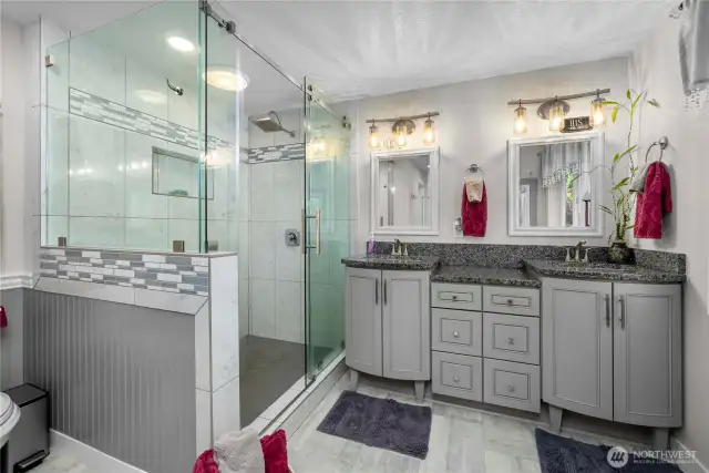 The huge primary bath with the elegant shower and beautiful floors.