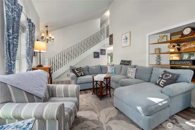 Here's another view of the front living room with beautiful new flooring and custom open rail staircase leading to the 3 upstairs bedrooms.  You also have 2 bedrooms, an office space and a full bath here on the main floor, as wel as a 1/2 bath in the laundry room.