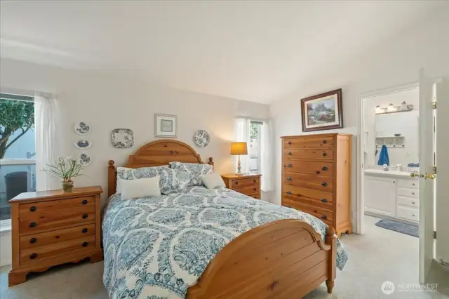 Primary bedroom and a view of entry to the primary bathroom with walk in shower, double sinks and commode area.