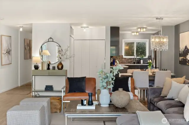 Entry hallway and storage and laundry nook in the middle to the left of a modern kitchen with eating space.