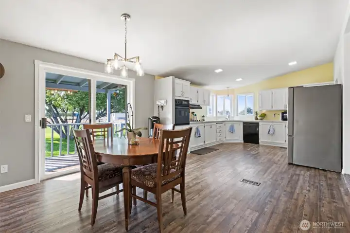 This photo showcases the open and inviting design, highlighting the functionality and aesthetic appeal of the combined eating and kitchen areas. The natural light, combined with the warm tones, creates a comfortable and welcoming atmosphere.