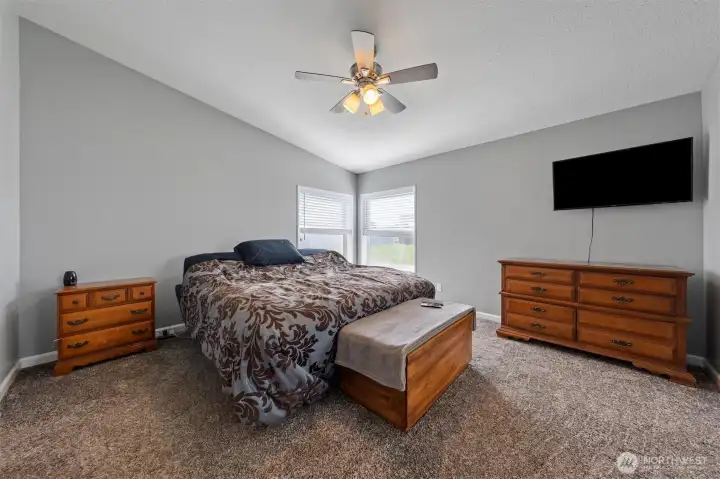 Spacious primary bedroom with ceiling fan and abundant natural light.