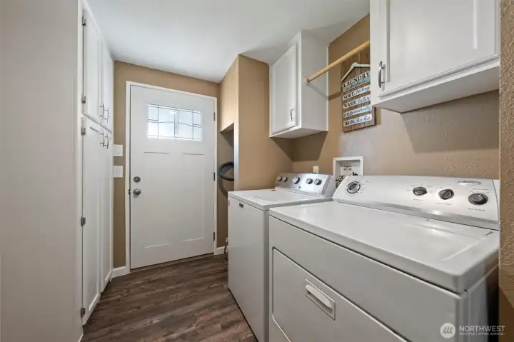 Spacious laundry area featuring plenty of storage and direct access to the backyard.