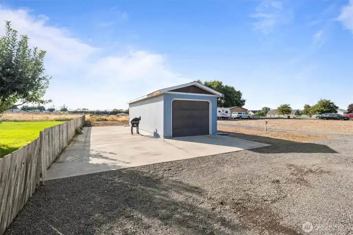 Detached garage in front of home on cement slab.