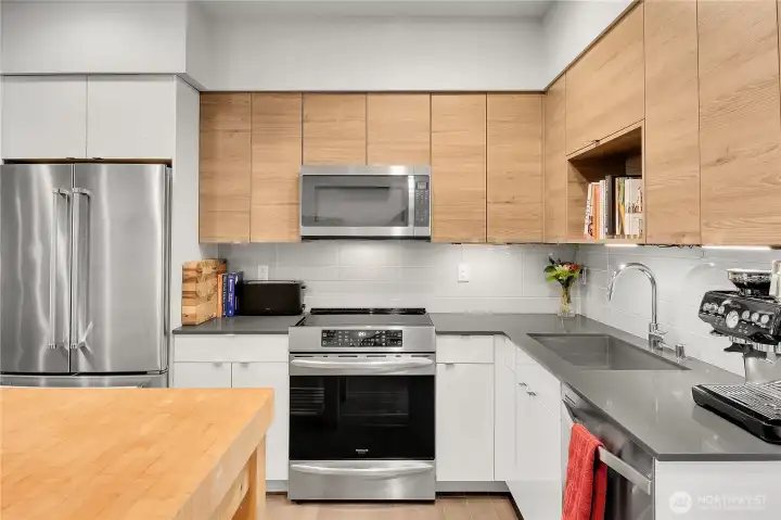 Open concept kitchen with stainless steel appliances and stone counters