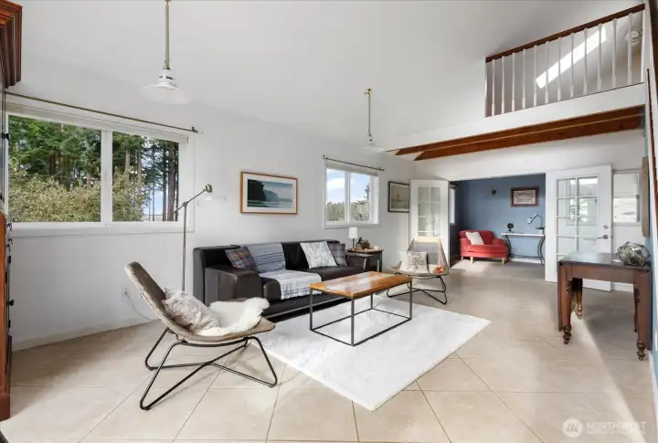 Living room showing french doors to office space beyond, loft above.