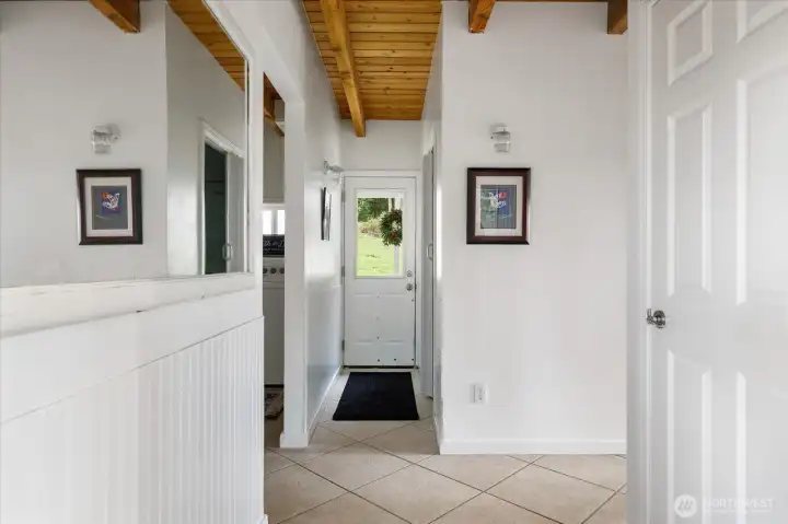 Hallway to dowstairs bath and covered porch beyond.