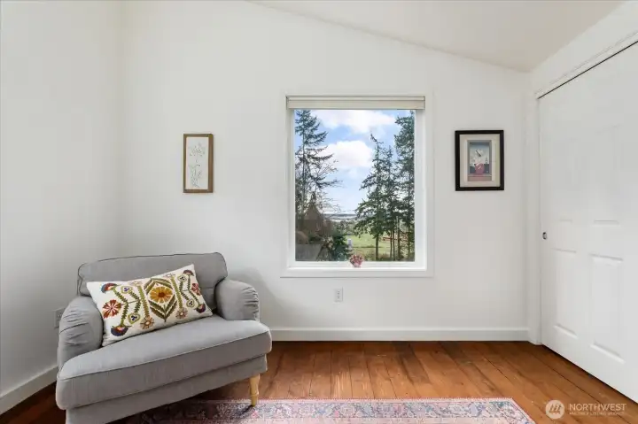 Primary bedroom has a beautiful view of the water, large closet, vaulted ceilings and a ceiling fan.