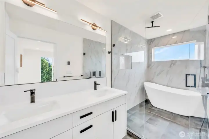 Extra-large primary bathroom with walk in shower/tub glass enclosure.