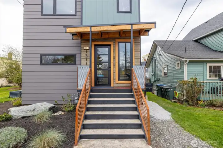 Covered Porch with wide steps and solid beams.  The siding is salvaged from the original house built on this lot.