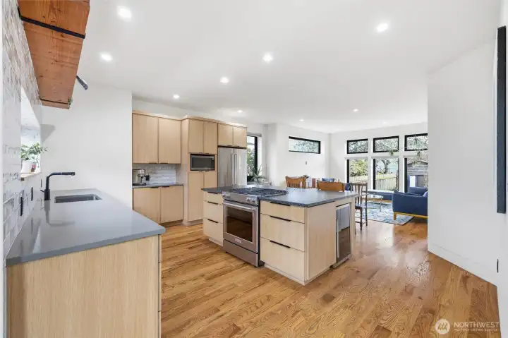 Kitchen with large honed granite island and beverage fridge.  Includes hidden multiple electric outlet plug-in