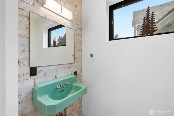 Guest bathroom with custom tile wall and character sink.