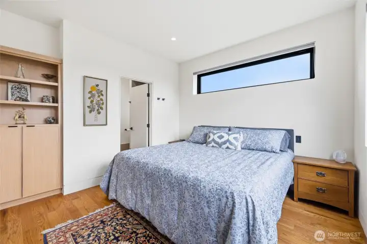 Primary bedroom with built-in cabinet.  Elevated window for light while maintaining privacy.