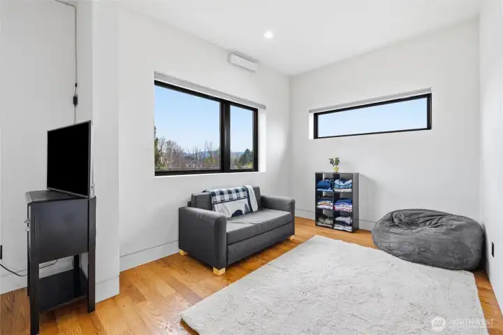 Bedroom is large enough for a couch has black-out curtains and vaulted ceilings.