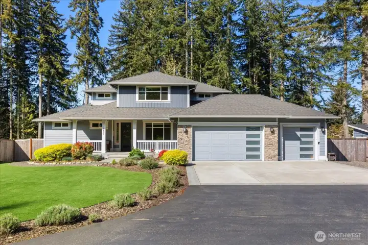 Beautifully designed home with strong curb appeal, set on a spacious lot surrounded by mature evergreens.