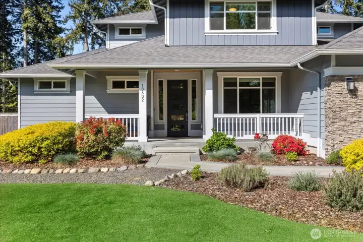 Inviting front approach with landscaped grounds and a welcoming covered entry.