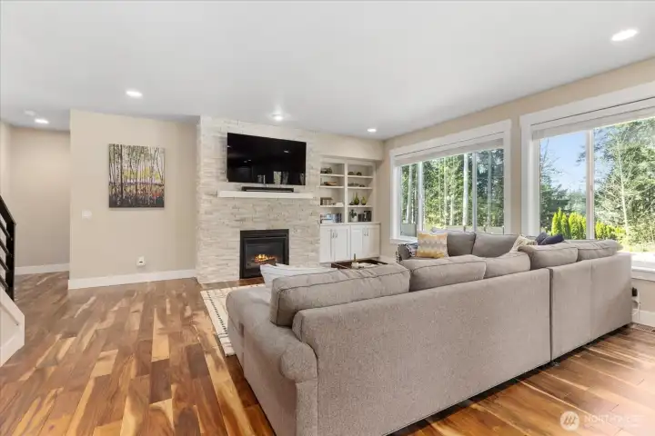 Stone-accent fireplace with built-ins creates a warm focal point for the main living space.