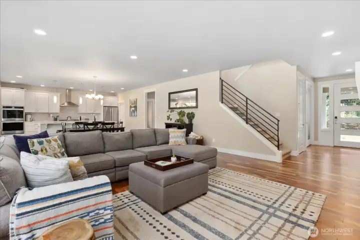 Open-concept main level with 9' ceilings, 8' doors, and a modern metal stair railing, offering a bright and spacious feel.