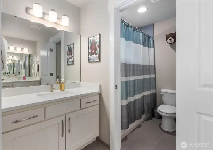 Full bathroom with dual access, modern finishes, and a functional layout.