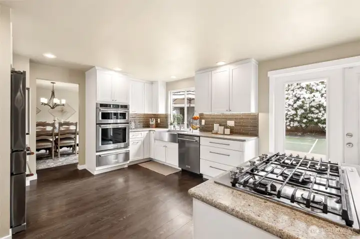 Abundant natural light pours in through oversized windows and glass door overlooking the backyard and pickleball court, while the open layout flows seamlessly to the dining area — perfect for everyday living and entertaining.