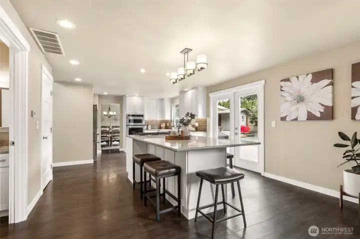 Expansive quartz-topped kitchen island with sleek contemporary styling, abundant prep space, and comfortable bar seating for casual dining or gathering with guests. The oversized design anchors the kitchen beautifully while adding functionality for entertaining, conversation, and everyday living.