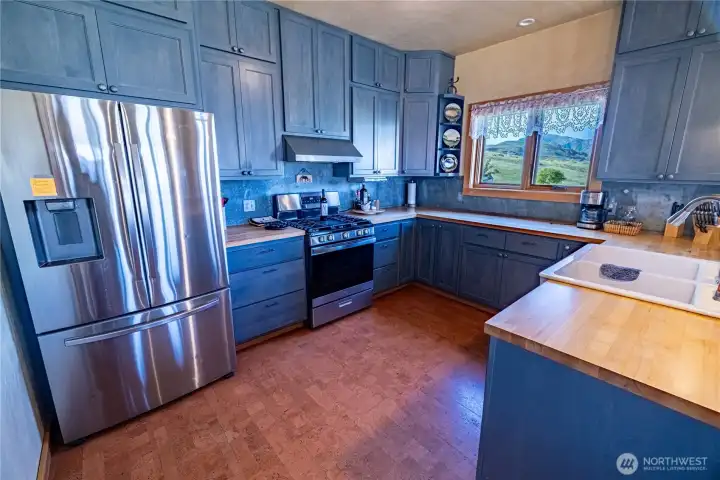 Kitchen showing butcher block counters, farm sink, magnetic backsplaches