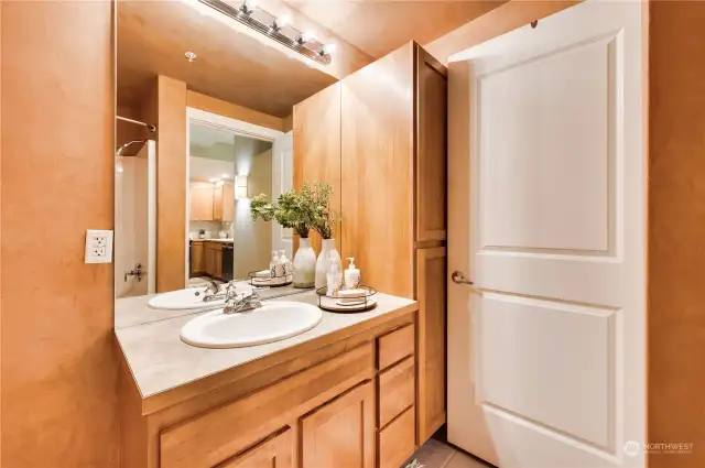 Bathroom has large soaking tub, vanity storage & additional built-in linen closet.