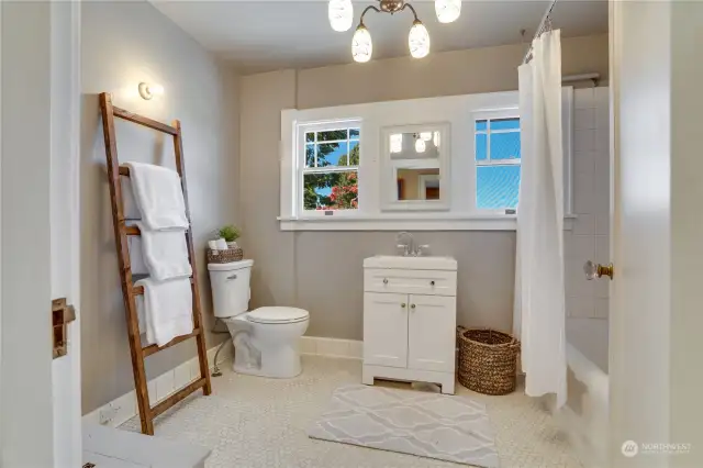 Upstairs full bathroom is bright & tile is style correct to the age of the home. To the left corner is a laundry chute.