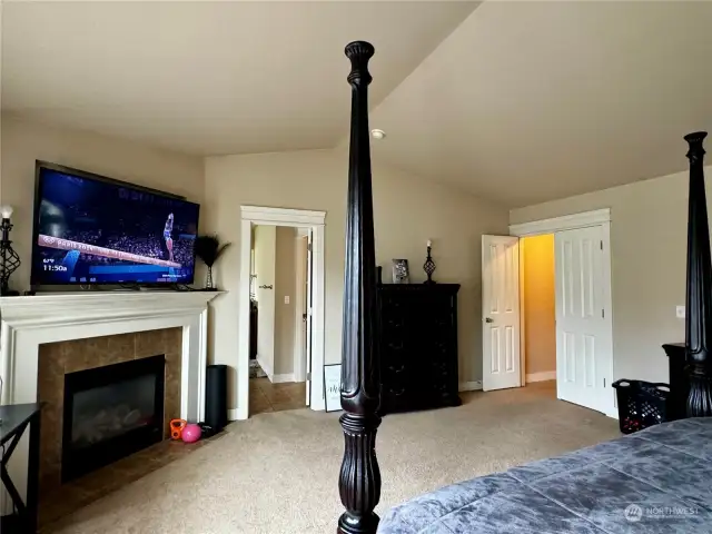 Another view of the primary bedroom with a gas fireplace.