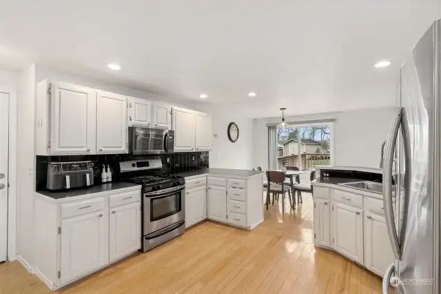 Here’s your kitchen’s power combo: gas range, stove, and microwave/hood vent, all working overtime. With a raised buffet bar ledge above the sink and a clear view to the dining area and slider, this kitchen is all about easy flow and smart design. Who knew cooking could look this good?