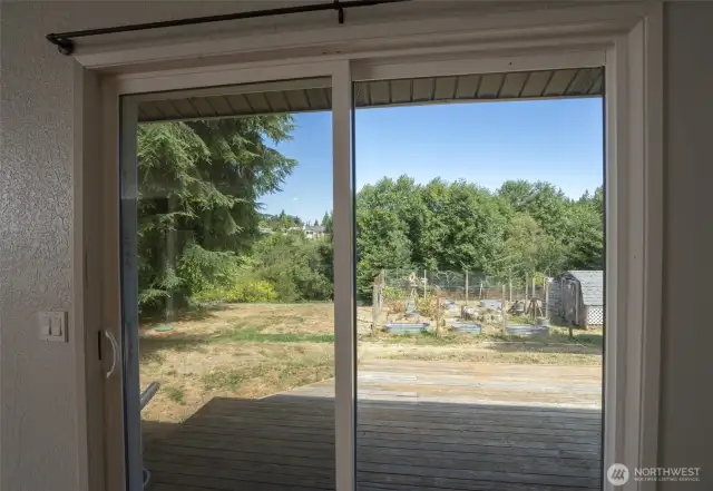 View of backyard through slider leading to deck