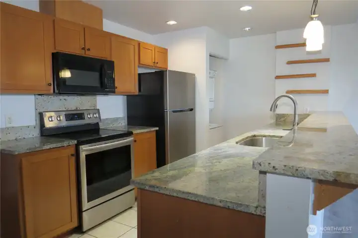 KITCHEN HAS TILE FLOORING, STAINLESS STEEL APPLIANCES, PLENTY OF CABINETS FOR STORAGE AND GRANITE COUNTER TOP AND EATING BAR!