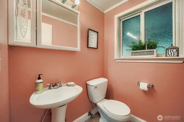Powder room on main floor with privacy window, medicine cabinet & crown molding