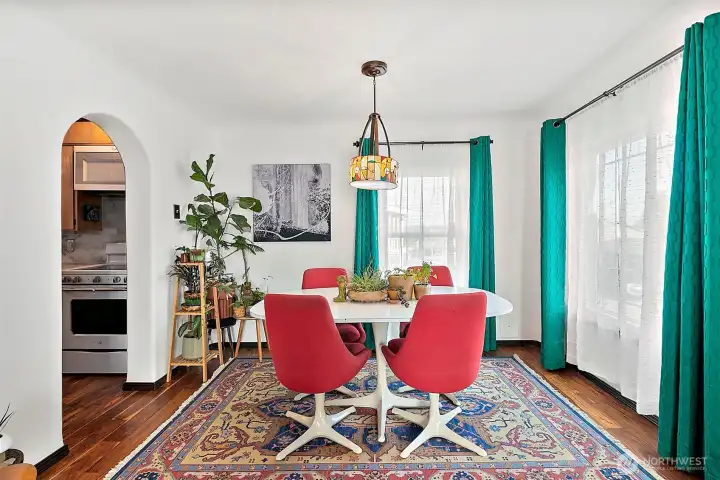 Dining room in front of house, just off the entry, living and kitchen for convenience and easy entertaining. Large windows bring in tons of natural light to the space. Chandelier fixture adds classic yet artistic charm to the space, along with the rounded entryway into the kitchen. Dark Hardwood floors bring dramatic character and contrast to the space.