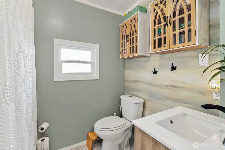 Full Bathroom with updated vanity and fixtures. Wall cabinetry for storage.