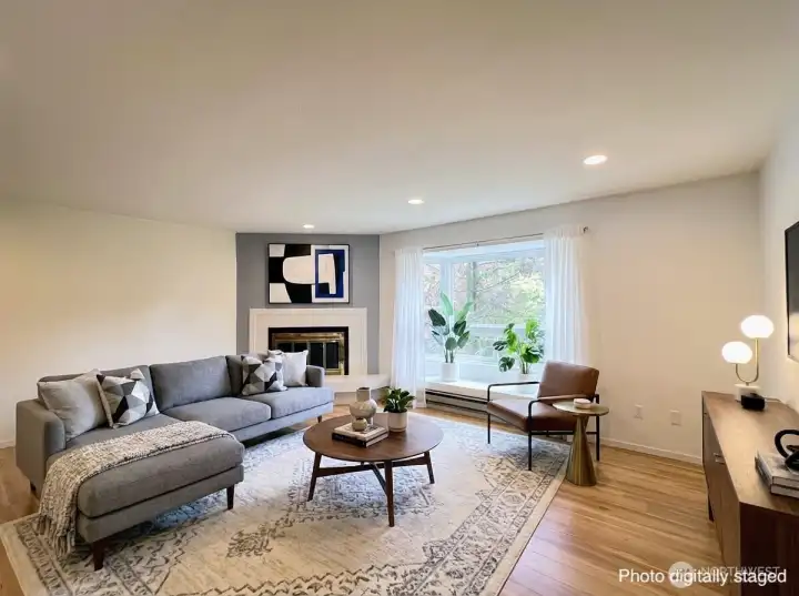 The e-staged living room has a large bow window.