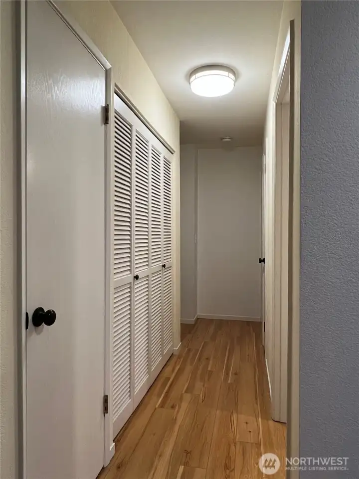 The laundry room is to the left behind the louvered doors.