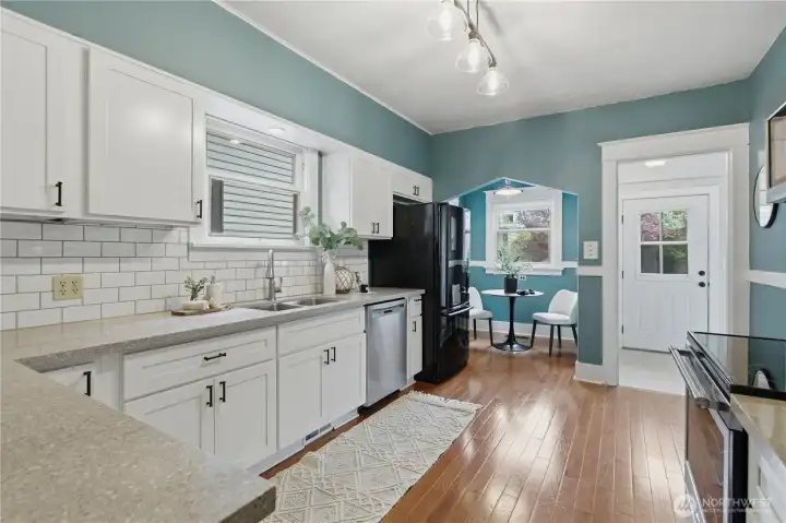 Totally remodeled kitchen with white shaker cabinetry, quartz counters, craftsman subway tile backsplash, all new oak hardwood flooring, and a wide open layout with room to cook and prepare gourmet food!
