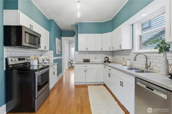 Kitchen view number three showing the oak hardwood hallway to the entry hall. Notice the lovely black craftsman hardware on all the cabinets as well.