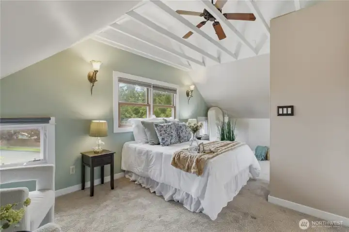Spacious primary bedroom with cool cathedral ceilings with ceiling fan!