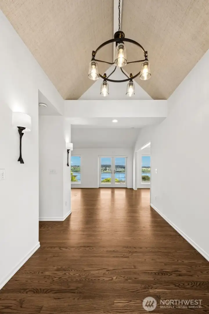 The front entry creates a striking first impression, where natural light, vaulted ceilings and shimmering reflections draw you forward the moment the door opens.