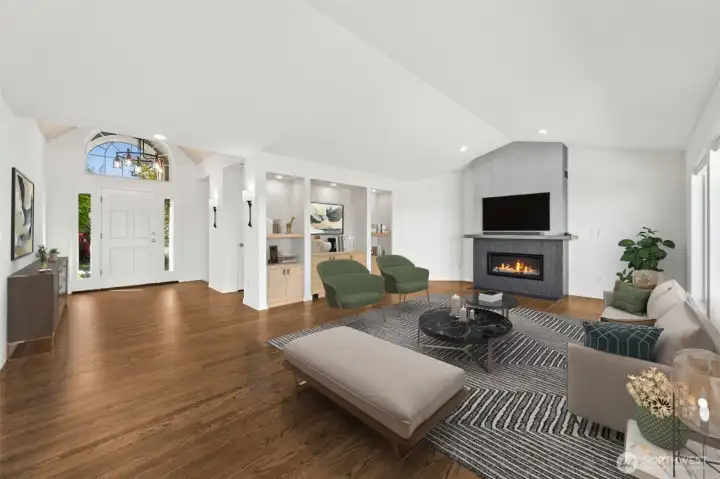 This family room showcases a new fireplace with grass cloth over wall covering and custom tile surround, vaulted ceilings, new custom alcove cabinets and floor to ceiling windows. (staged photo)