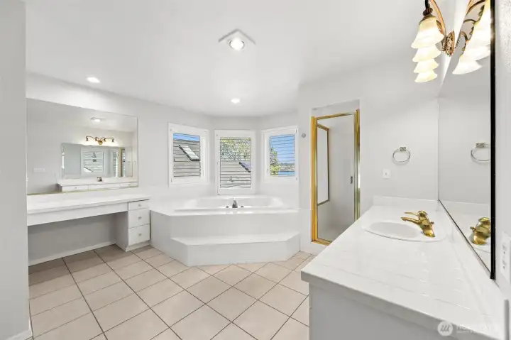 Generous sized en-suite bathroom with soaking tub, multiple vanity areas & walk-in shower.