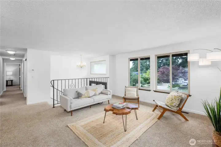 Main level living room and hallway that leads to three bedrooms and two bathrooms.