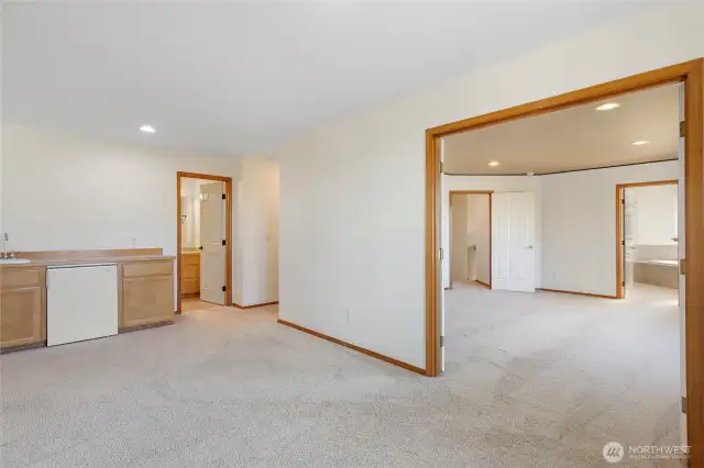 View from the Gigantic Upstairs Bonus room looking back towards the Primary Suite with French Doors.Another upstairs bathroom in the center of the pic.Room comes with its own refrigerator and sink