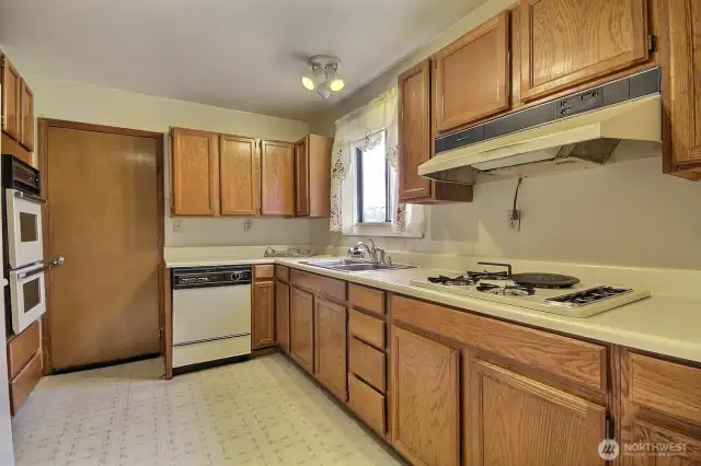 Kitchen features oak cabinets, a gas cook, walk-in pantry and overlooks the side yard on the north side of the property.