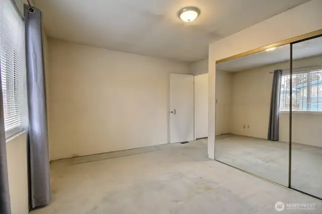 Main floor bedroom feautres large closet and over looks the vacant parcel/side yard to the south.