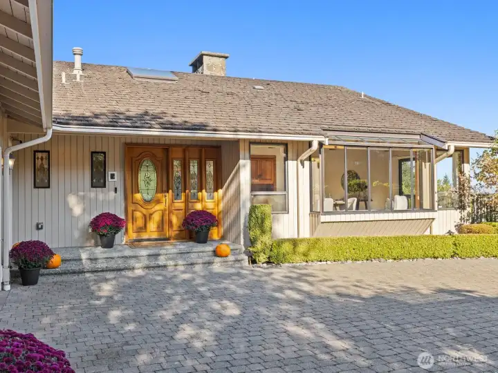 A large covered front porch gives you access from the well-equipped garage with electric car charger, utility sink and built-in storage.